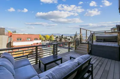 a balcony with a couch and a table on a roof at Experience the charm of Frisco in this spacious townhome, Decked Out Downtown, private hot tub in Frisco