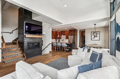 a living room with a white couch and a kitchen at Experience the charm of Frisco in this spacious townhome, Decked Out Downtown, private hot tub in Frisco