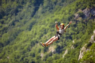 a woman flying through the air on a zip line at The Pine Getaway on 60 Acres with Hot Tub in Pine