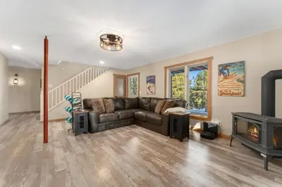 a living room with a couch and a fireplace at The Pine Getaway on 60 Acres with Hot Tub in Pine