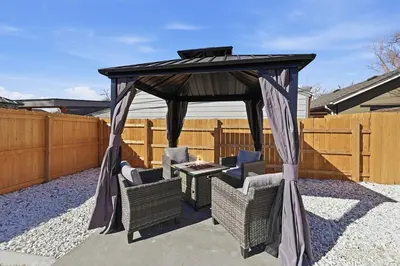 a gazebo with chairs and a table in a backyard at Cozy 2BR Retreat with Backyard Lounge in Aurora