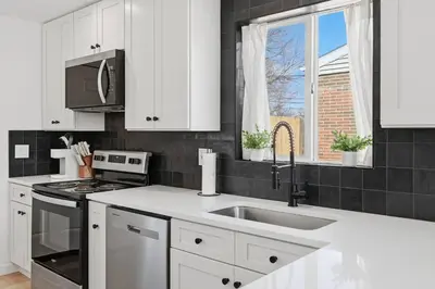a kitchen with white cabinets and a sink at Cozy 2BR Retreat with Backyard Lounge in Aurora