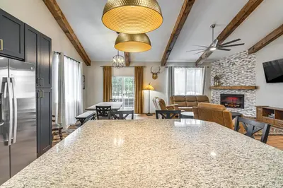 a kitchen and living room with a large marble counter top at Hike and Fish Group Getaway with Hot Tub in Bailey! in Bailey
