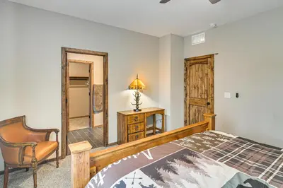 a bedroom with a bed and a chair and a mirror at Hike and Fish Group Getaway with Hot Tub in Bailey! in Bailey