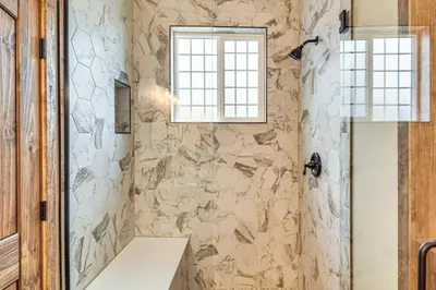 a bathroom with a stone wall at Hike and Fish Group Getaway with Hot Tub in Bailey! in Bailey