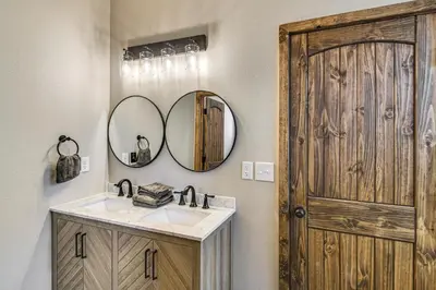 a bathroom with a wooden door and a sink and mirror at Hike and Fish Group Getaway with Hot Tub in Bailey! in Bailey