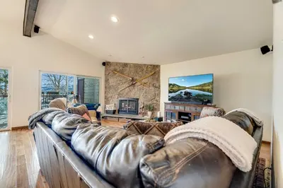 a living room with a leather couch and a fireplace at Serene Nordic-Inspired Lakeside Retreat with Panoramic Mountain Views Near Breckenridge, Dillon, Colorado in Dillon