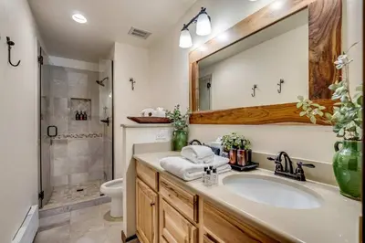 a bathroom with a sink and a toilet and a mirror at Serene Nordic-Inspired Lakeside Retreat with Panoramic Mountain Views Near Breckenridge, Dillon, Colorado in Dillon