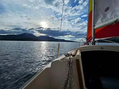 a boat on a large body of water at Serene Nordic-Inspired Lakeside Retreat with Panoramic Mountain Views Near Breckenridge, Dillon, Colorado in Dillon