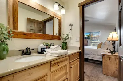 a bathroom with a sink and a mirror and a bed at Serene Nordic-Inspired Lakeside Retreat with Panoramic Mountain Views Near Breckenridge, Dillon, Colorado in Dillon