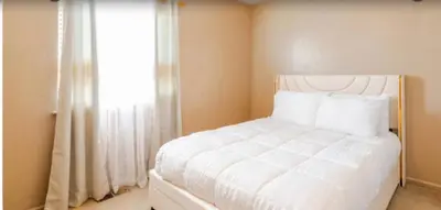 a bedroom with a white bed and a window at Iman in DEN