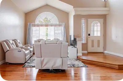a living room with white chairs and a television at Iman in DEN