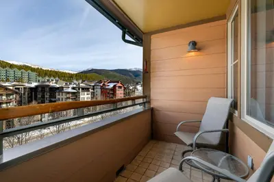 a balcony with chairs and a view of a city at Premium Unit 2502 - 2BR - Zephyr Mountain Lodge condo in Winter Park