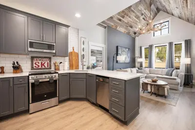 a kitchen with gray cabinets and a living room at Premium Unit 2502 - 2BR - Zephyr Mountain Lodge condo in Winter Park