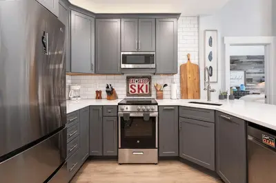 a kitchen with gray cabinets and a stove at Premium Unit 2502 - 2BR - Zephyr Mountain Lodge condo in Winter Park