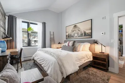 a bedroom with a bed and a desk and windows at Premium Unit 2502 - 2BR - Zephyr Mountain Lodge condo in Winter Park