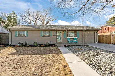 a house with a fence and two chairs in the driveway at Cherry Creek Jasmine Retreat in Denver CO in Denver
