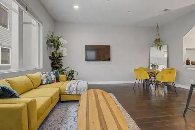 a living room with a yellow couch and a table at Spacious Denver Home with Private Rooftop Spa in Denver