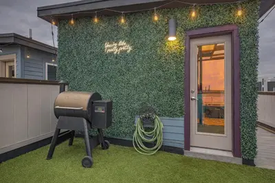 a backyard with a grill and a green wall at Spacious Denver Home with Private Rooftop Spa in Denver