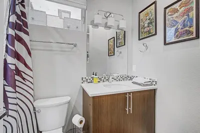 a white bathroom with a toilet and a sink at Spacious Denver Home with Private Rooftop Spa in Denver