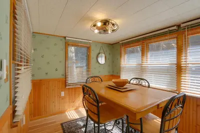 a dining room with a wooden table and chairs at Riverfront Drake Home - 10 Mi to Estes Park! in Drake
