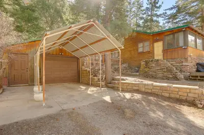 a garage in front of a wooden house at Riverfront Drake Home - 10 Mi to Estes Park! in Drake