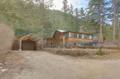 a large wooden house in the middle of a forest at Riverfront Drake Home - 10 Mi to Estes Park! in Drake