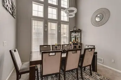 a dining room with a table and chairs and a mirror at 6 Mi to Buckley Space Force Base Getaway with Patio in Aurora