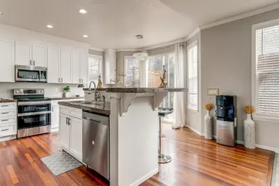 a kitchen with white cabinets and a counter top at 6 Mi to Buckley Space Force Base Getaway with Patio in Aurora