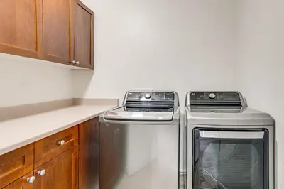 a kitchen with a stove and a washer and dryer at 6 Mi to Buckley Space Force Base Getaway with Patio in Aurora