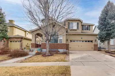a house with a tree and a garage at 6 Mi to Buckley Space Force Base Getaway with Patio in Aurora