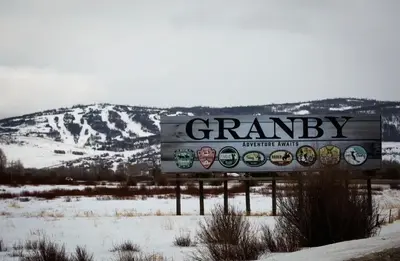 a sign in the snow with a mountain in the background at Base Camp 402 condo in Granby