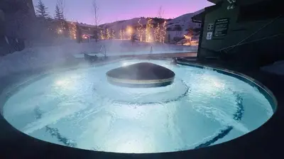a hot tub filled with blue water with aperature at Base Camp 402 condo in Granby