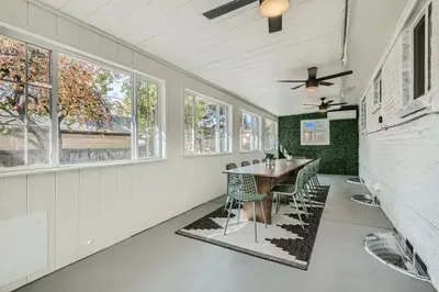 a dining room with a table and chairs and windows at Private Home - Hot Tub, Game Room, Fire Pit, Fenced Yard in Westminster
