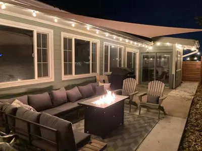 a patio with a couch and a table and chairs at Private Home - Hot Tub, Game Room, Fire Pit, Fenced Yard in Westminster