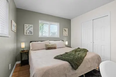 a bedroom with a bed with a green blanket on it at Private Home - Hot Tub, Game Room, Fire Pit, Fenced Yard in Westminster