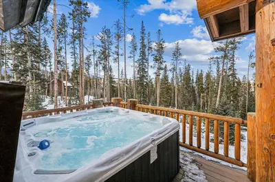 a hot tub on the deck of a cabin at Experience Fireside Retreat, a comfortable and secluded log home in Breckenridge, Hot Tub in Breckenridge