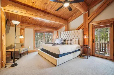 a bedroom with a large bed in a room with wooden ceilings at Experience Fireside Retreat, a comfortable and secluded log home in Breckenridge, Hot Tub in Breckenridge