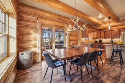 a dining room with a wooden table and chairs at Experience Fireside Retreat, a comfortable and secluded log home in Breckenridge, Hot Tub in Breckenridge