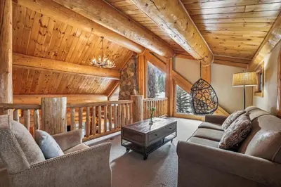 a living room with a couch and chairs in a cabin at Experience Fireside Retreat, a comfortable and secluded log home in Breckenridge, Hot Tub in Breckenridge