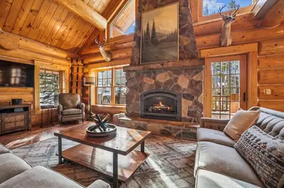 a living room with a fireplace in a log cabin at Experience Fireside Retreat, a comfortable and secluded log home in Breckenridge, Hot Tub in Breckenridge