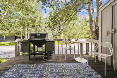 a grill on a patio with a table and chairs at Stay at Frisco Creekside Retreat! Located in a great location in Frisco