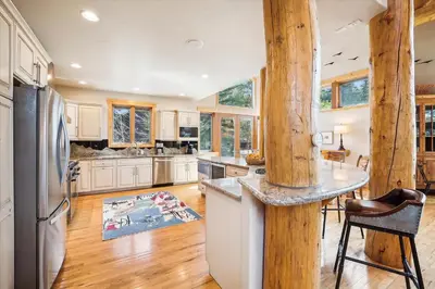 a kitchen with white cabinets and a wooden pillar at Experience Frisco Fling, a spacious house in the heart of Frisco with a hot tub and wooded views in Frisco