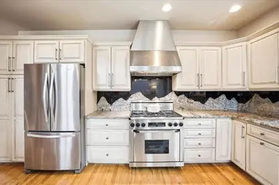 a kitchen with white cabinets and a stainless steel refrigerator at Experience Frisco Fling, a spacious house in the heart of Frisco with a hot tub and wooded views in Frisco