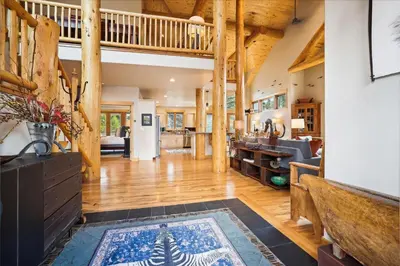 a large living room with wooden floors and a staircase at Experience Frisco Fling, a spacious house in the heart of Frisco with a hot tub and wooded views in Frisco