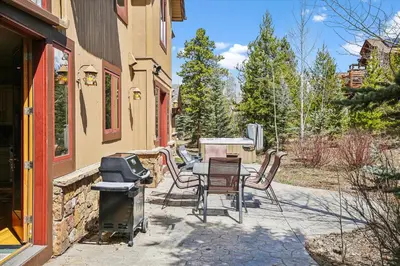 a patio with a grill and a table and chairs at Experience Frisco Fling, a spacious house in the heart of Frisco with a hot tub and wooded views in Frisco