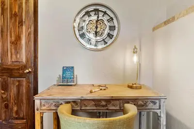 a wooden desk with a clock on the wall at Family Mountain Getaway w Hot Tub and Amazing Views! Close to Hiking & Skiing in Idaho Springs