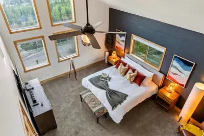 a bedroom with a large bed in a room with windows at Family Mountain Getaway w Hot Tub and Amazing Views! Close to Hiking & Skiing in Idaho Springs