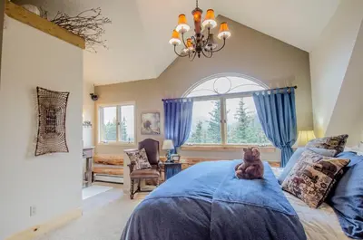 a teddy bear sitting on a bed in a bedroom at The Silver Lake Lodge - Adults Only in Idaho Springs