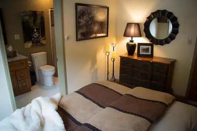 a bedroom with a bed with a dresser and a mirror at The Silver Lake Lodge - Adults Only in Idaho Springs
